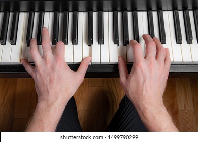 Close Up Of A Man Playing The Piano. Left Hand Plays A Power Chord And Right Hand Plays The Melody.
