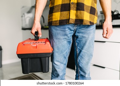 Close up man plumber holding toolbox in the kitchen a prepare for work