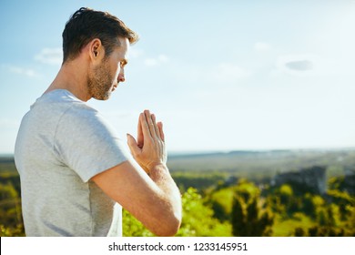 Close up of man praying while standing peacefully on meadow