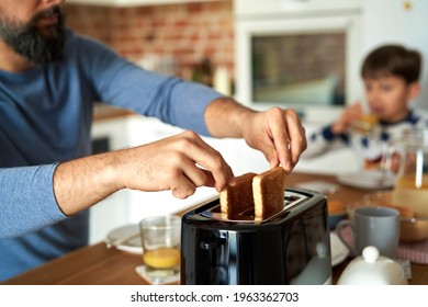 Close Up Of Man Pulling Toast From A Toaster