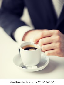 Close Up Of Man Putting Sugar Into Coffee