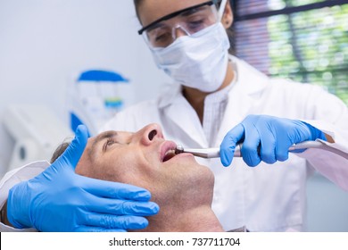 Close up of man receiving dental treatment by dentist at clinic - Powered by Shutterstock