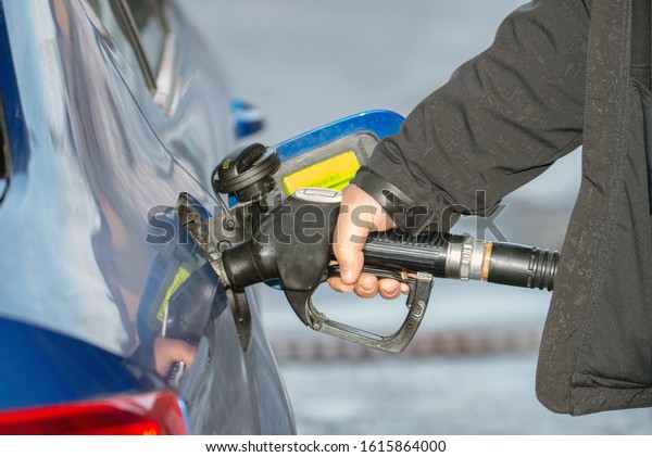 Close up of man refilling tank on his car on the\
gas station. Price is\
rising