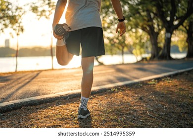 Close up - Man runner stretching leg and feet and preparing for jogging and running in public park outdoors at sunset, Active and healthy lifestyle concept, copy space - Powered by Shutterstock