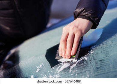 Close Up Of Man Scraping Ice From The Windshield Of A Car