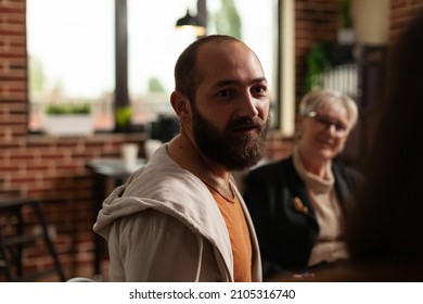 Close up of man sharing addiction problems with aa meeting people and specialist. Person explaining anxiety and depression issues at support therapy with psychiatrist sitting in circle. - Shutterstock ID 2105316740