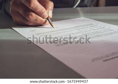 close up of a Man signing  french authorization to go out side, concept quarantine in France.