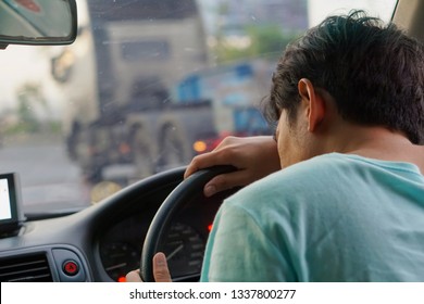 Close up of a man sleeping while driving.