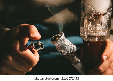 Close Up Of Man Smoking Pot, Medical Marijuana Or Cannabis From A Bong Or Water Pipe. Cannabis And Weed Legalisation Concept