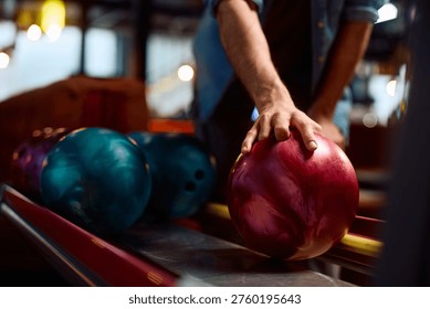 Primer plano del hombre que toma una pelota mientras que juega boliche de diez alfileres en el club.