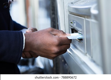 Close up of man taking cash from ATM with credit card.