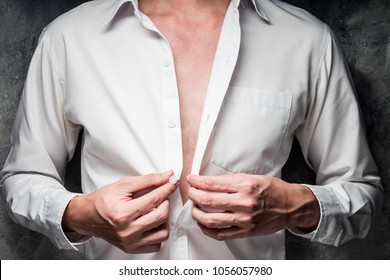 Close Up Of A Man Taking Off His White Shirt On Gray Grunge Background