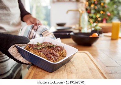 Close Up Of Man Taking Vegetarian Nut Roast Out Of Oven For Christmas Dinner