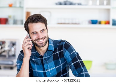 Close up of man talking on mobile in the kitchen - Powered by Shutterstock