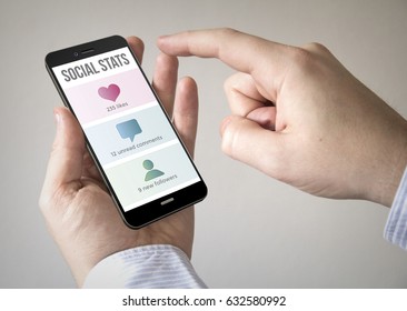 Close up of man using 3d generated mobile smart phone with social stats on the screen. Screen graphics are made up.