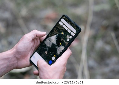 close up of a man using gps navigation app on his smartphone in nature mountain, male hands holding smartphone, man using his smartphone like a navigator in a forest. Close up hands. - Powered by Shutterstock