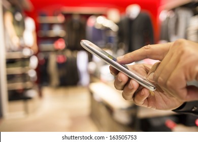 Close Up Of A Man Using Mobile Phone In Clothing Store