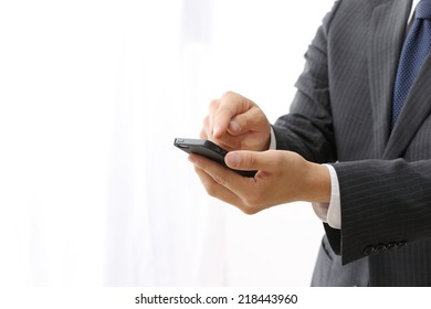 Close up of man using mobile smart phone isolated on white background