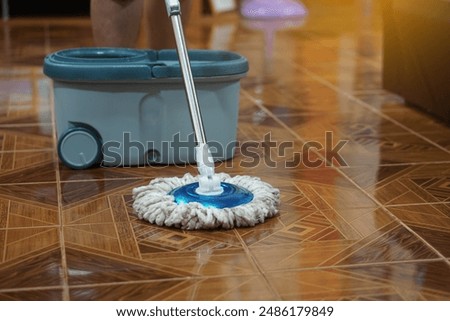 Close up of man using a mop to mop the floor. Concept, chore. Household. Housework. Cleaning house. Housekeeping for sanitary or hygienic. Daily routine lifestyle.                                     