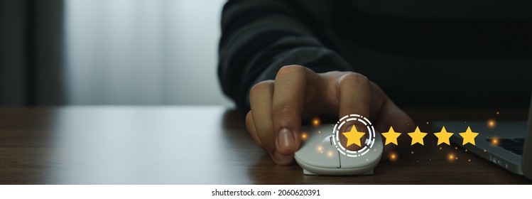 Close up man using mount computer for rating feedback from customer service with annual survey with five gold star icon. Business annual satisfaction survey concept. User reviews and feedback online. - Shutterstock ID 2060620391