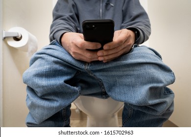 Close up of a man using smart phone in toilet or restroom