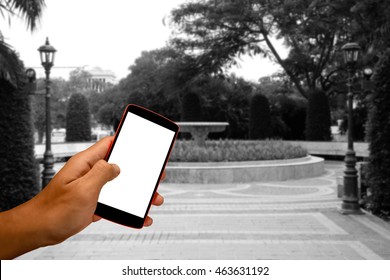 Close Up Of A Man Using Smart Phone With Blank Mobile And Landscape Blur Background.Smart Phone With Blank Screen And Can Be Add Your Texts Or Others On Smart Phone..
