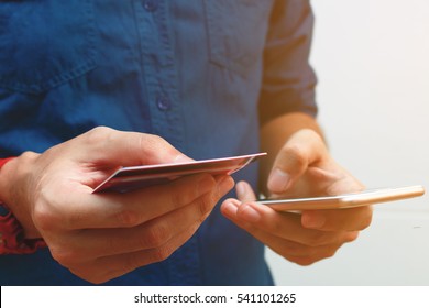 Close up man using smart phone and holding credit card with shopping online. Online payment concept.