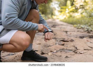 Close up man using smart watch to monitor performance, setting up his smart watch before exercise.