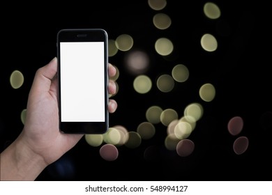Close up of a man using smartphone with blank screen mobile and bokeh background.