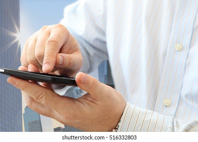 Close up of man using smartphone on urban background 