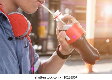 Close Up Man Ware Headphone And Drink Soda Pop On Bottle