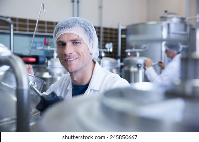 Close up of a man wearing a hair net looking at the camera in the factory - Powered by Shutterstock