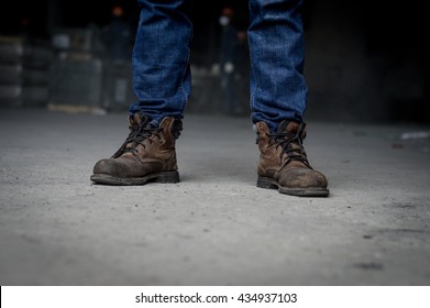 Close up of Man wearing safety shoes brown color , standing on the street.