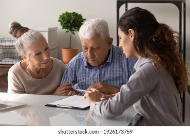 Close up manager realtor advisor consulting mature couple about contract terms at meeting, senior family involved in negotiations, making insurance or investment deal, purchasing real estate
