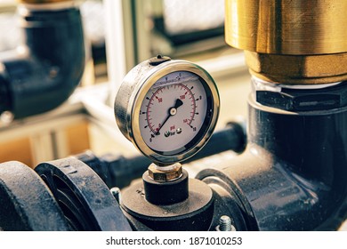 Close up of manometer measuring water pressure. Pipes and valves at industrial plant. - Shutterstock ID 1871010253