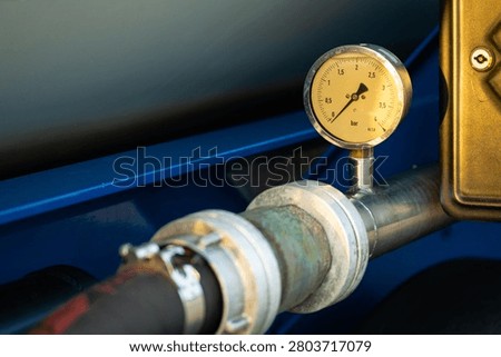 Close up of a manometer manometer mounted on blue metal tubes system