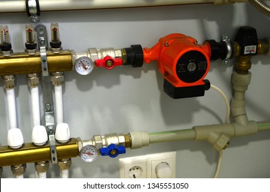 Close up of manometer, pipe, flow meter, water pumps and valves of heating system in a boiler room. Copper valves, stainless ball valves, detector of water and plastic pipes of central heating system 