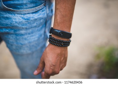 Close Up Of A Man's Arm Wearing A Smart Band And A Bracelet