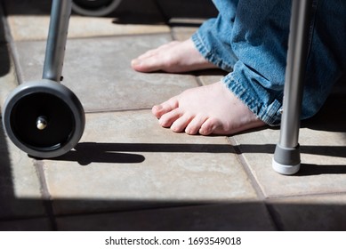 Close Up Man's Bare Feet Wearing Jeans Standing In His Walker For Assistance. 