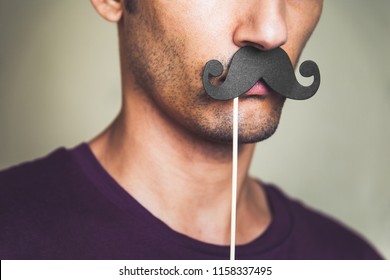 close up of a man's chin wearing a fake paper made mustache