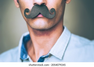 close up of a man's chin wearing a fake paper made mustache - Celebration of Movember