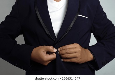 Close up of a man's hand buttoning his suit jacket