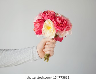 Close Up Of Man's Hand Giving Bouquet Of Flowers.
