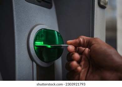 Close up of man's hand inserting a credit card in an ATM to deposit cash in the bank account - Shutterstock ID 2303921793