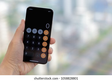 Close up man's hand open calculator app on his smartphone with blurred background. To start using calculator application. Technology Concept