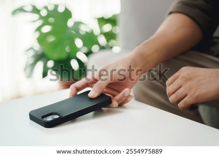 Close up of a man's hand is to put his mobile phone on the table after stopping using it. The concept of screen time limit.