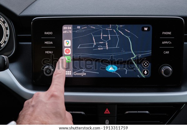Close up mans hand select the application of navigation\
or maps on the car dashboard. January 2021, Prague, Czech Republic.\
