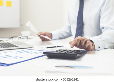 Close up of man's hands. He is using his calculator and holing document in the second hand. Concept of multitasking - Shutterstock ID 503268241