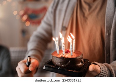 Close up of man's hands holding birthday cake with lit candles for anniversary or birthday. Cropped view - Powered by Shutterstock