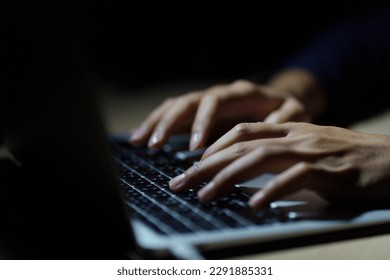Close up of a man's hands on keyboard of lap top in the dark room, people working at home, modern white notebook. Internet, work, technology concept.